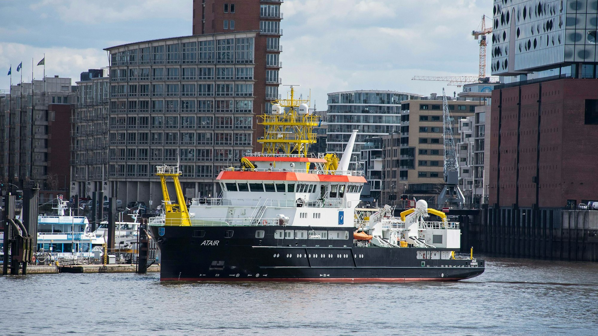 Das Forschungsschiff Atair des BSH liegt im Hamburger Hafen, am rechten Bildrand ist die Hamburger Elbphilharmonie zu sehen.