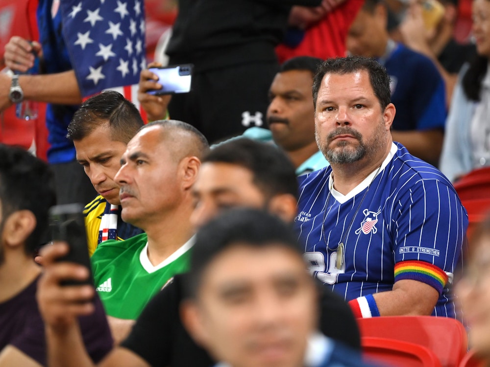 Ein US-Fan sitzt bei der WM 2022 im Stadion. Er trägt ein Regenbogen-Armband