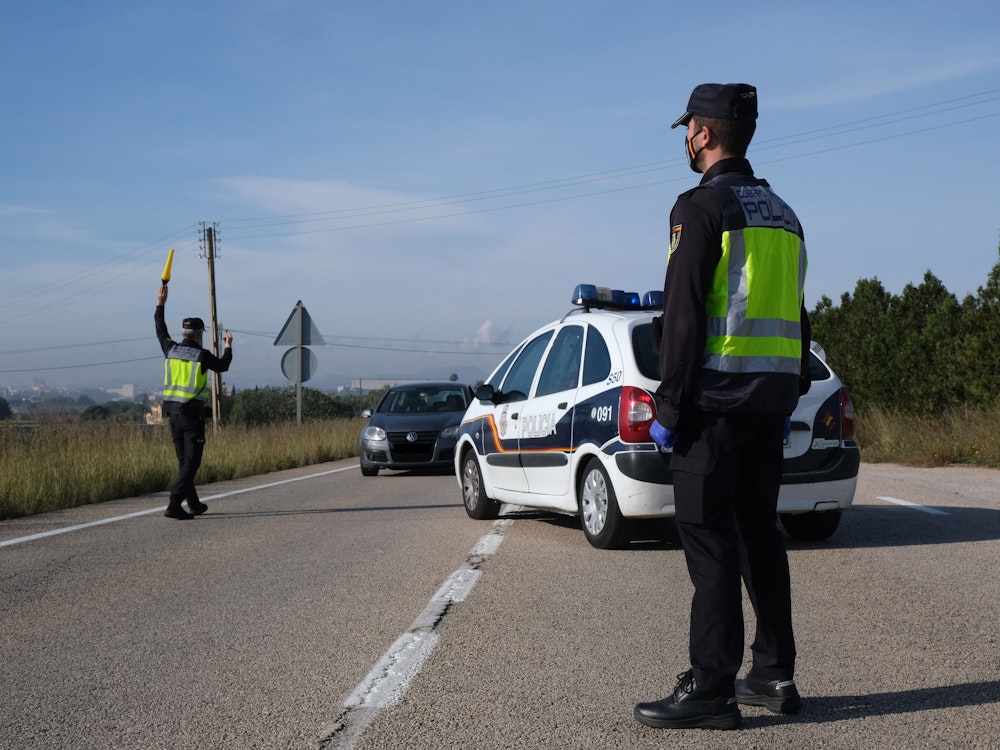 Polizisten führen am Eingang der Stadt Manacor auf der Insel Mallorca Fahrzeugkontrollen durch.