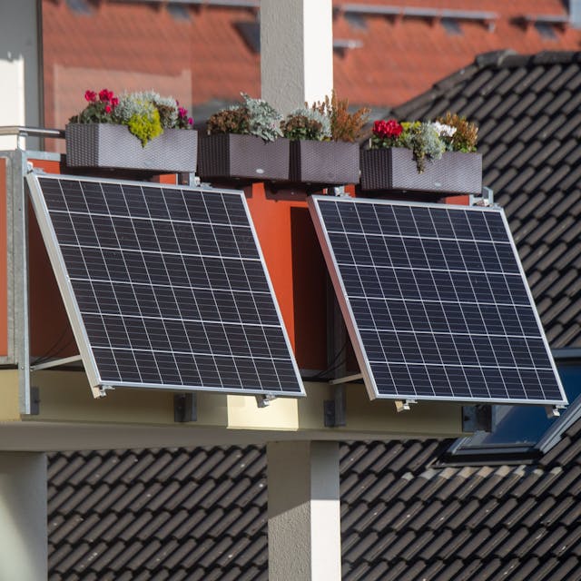 Solarmodule für ein sogenanntes "Balkonkraftwerk" hängen an einem Balkon.