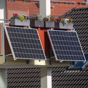 Solarmodule für ein sogenanntes "Balkonkraftwerk" hängen an einem Balkon.