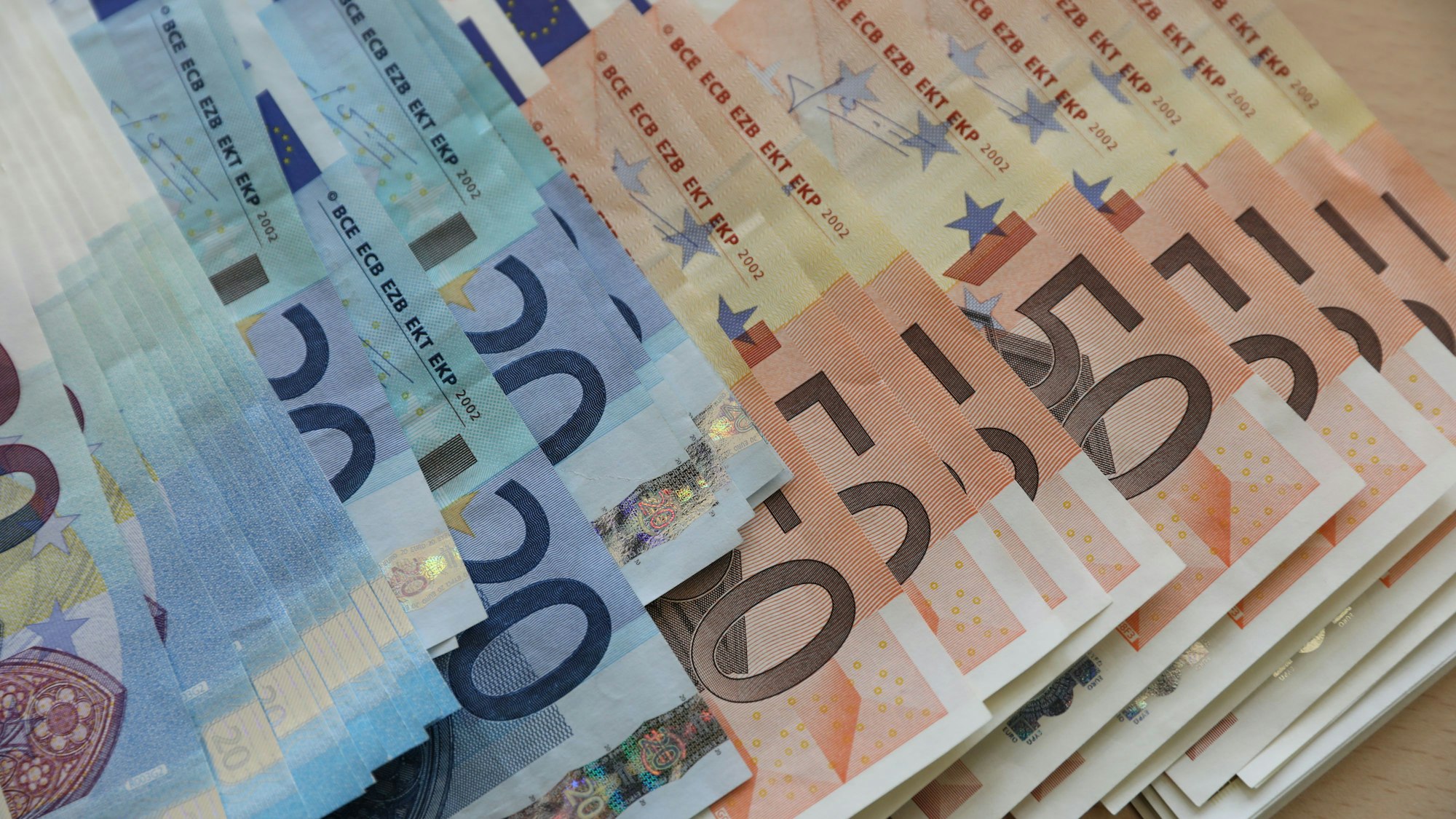 Mehrere Euro-Geldscheine liegen auf einem Stapel (Symbolbild)