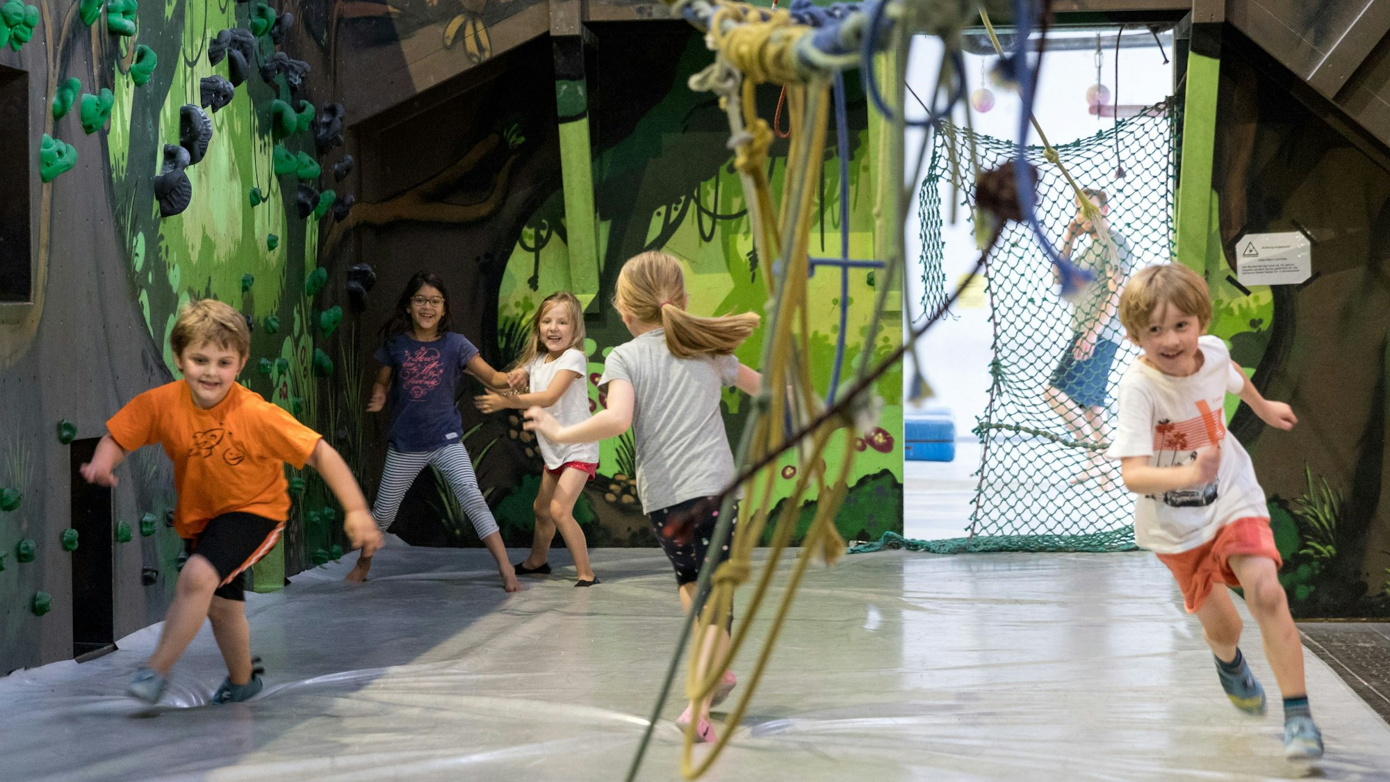 Kinder toben im Stuntwerk Köln in einer Halle.
