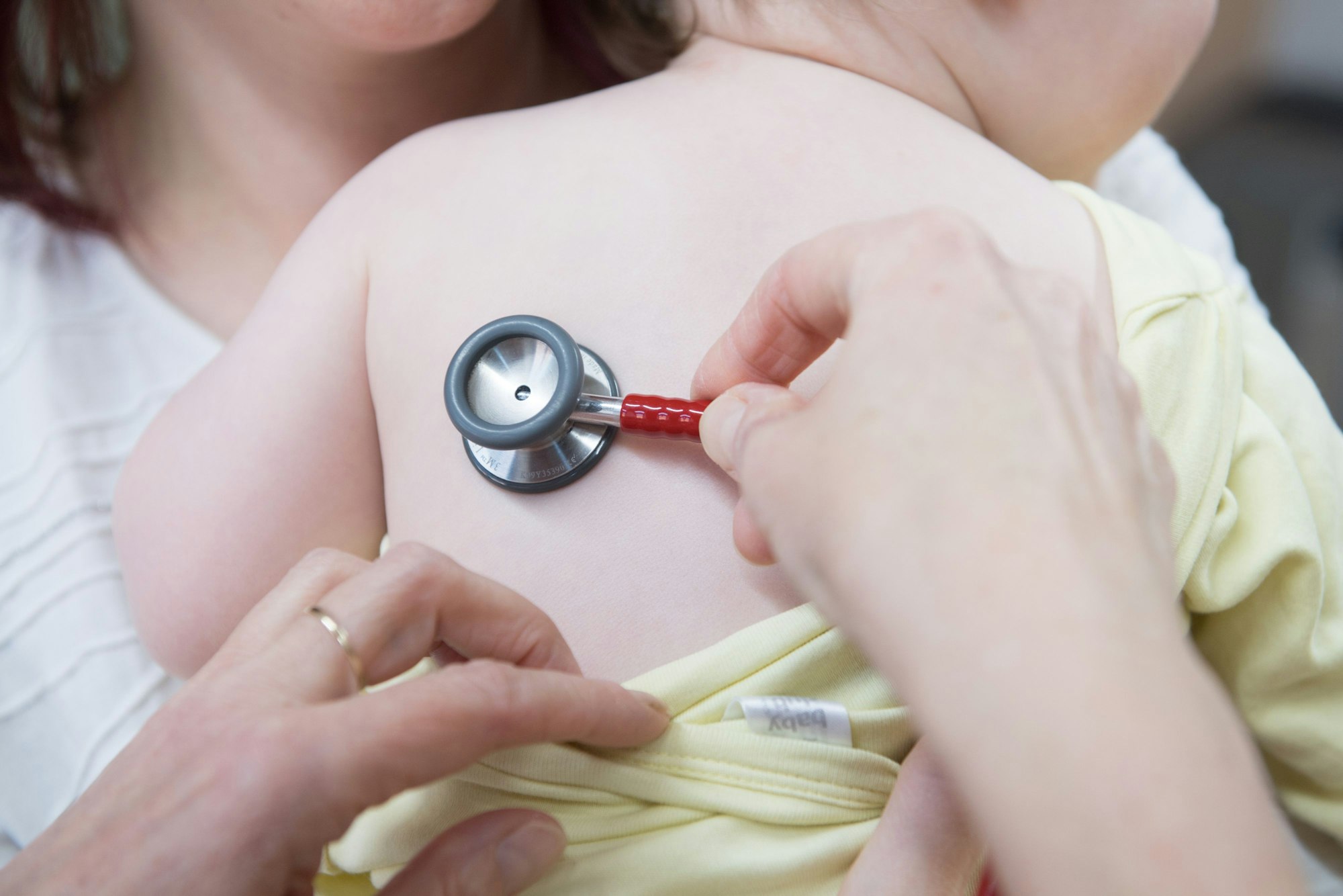 Eine Kinderärztin untersucht ein Kleinkind mit einem Stethoskop