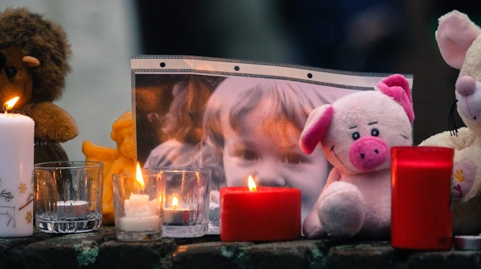 Kerzen, Stofftiere und ein Bild der ermordeten Lea Sofie sind auf einer Mauer am Pariser Platz in Chorweiler aufgestellt worden