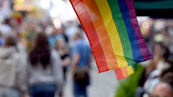Regenbogenflaggen sind im Juli 2022 zum Start des CSD-Wochenendes an einem Marktstand in Köln angebracht.