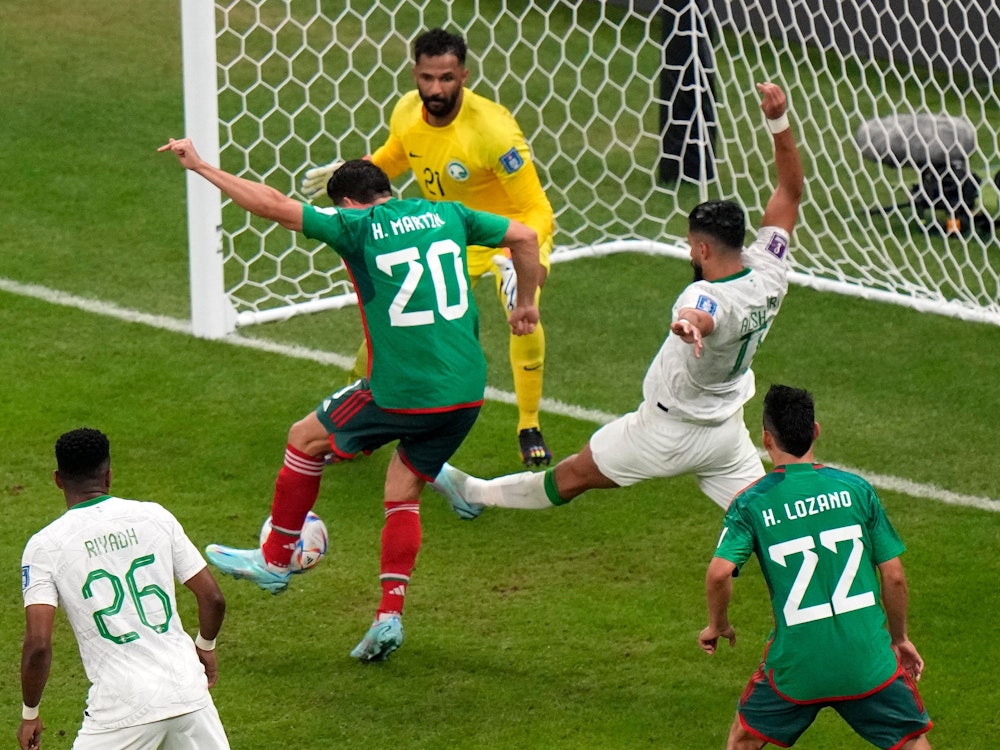 Henry Martin trifft zum 1:0 für Mexiko, Saudi-Arabiens Verteidiger versucht mit gestrecktem Bein das Tor zu verhindern.