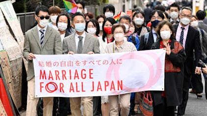 Unterstützer der „Ehe für alle“ laufen zum Bezirksgericht in Tokio. Sie halten ein Banner mit der Aufschrift „Ehe für ganz Japan“ hoch.