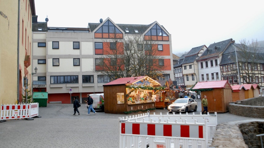 Ein Auto fährt zwischen den Verkaufsbuden des Weihnachtsmarkts in Bad Münstereifel hindurch.