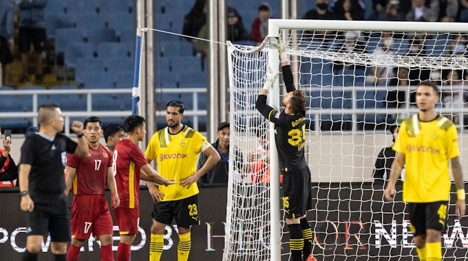Marcel Lotka von Borussia Dortmund berührt das Torgestänge mit seinem Handschuh und versucht, ein kaputtes Tor zu reparieren.