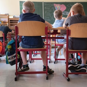 Schülerinnen und Schüler sitzen nebeneinander im Klassenraum einer Grundschule.