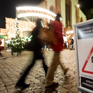 Symbolbild: 27.11.2017, Baden-Württemberg, Freiburg: Menschen gehen über den eröffneten Weihnachtsmarkt. Ein Schild warnt vor Taschendieben.