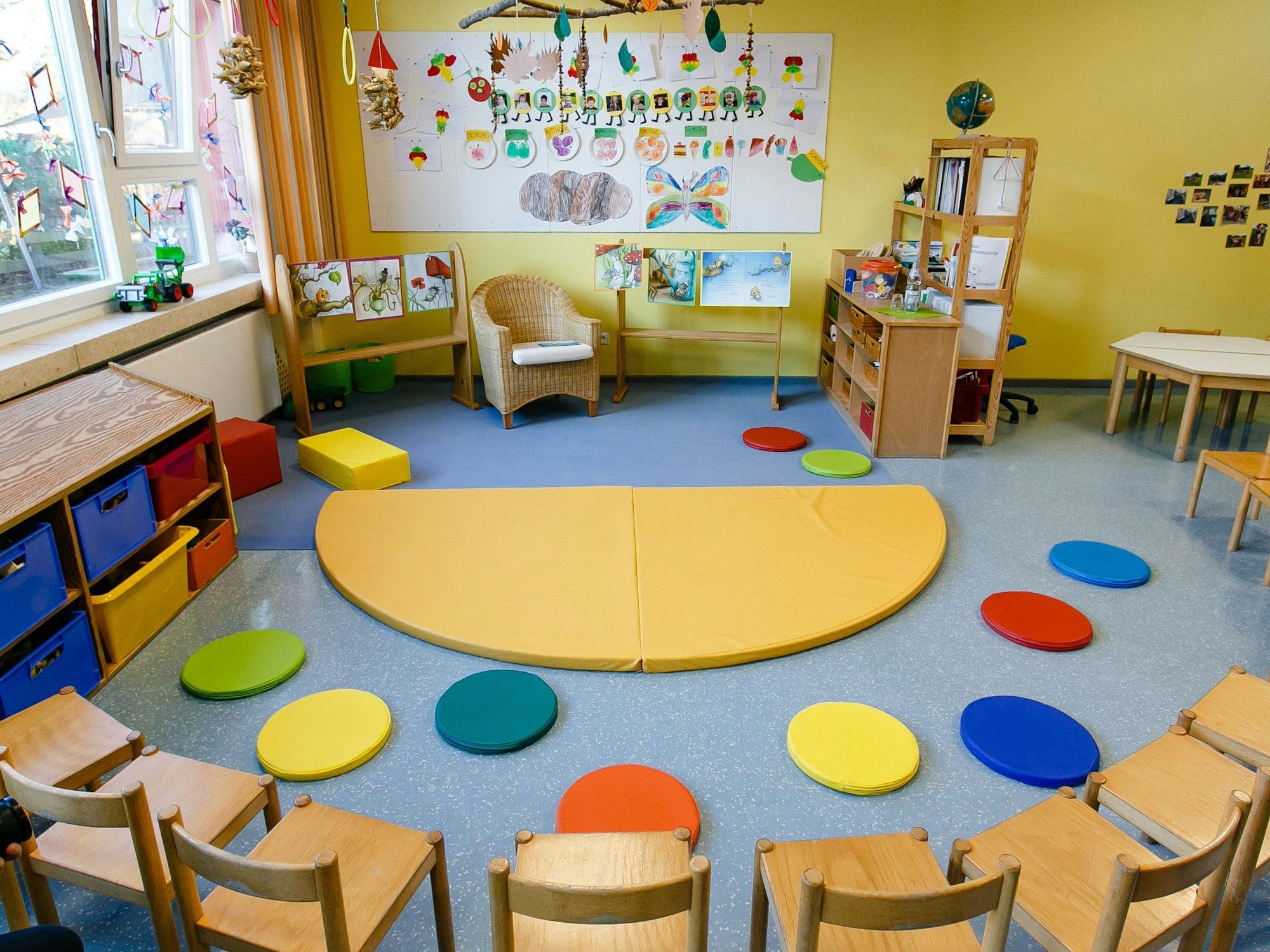 Stühle stehen im Halbkreis im Gruppenraum einer Kindertagesstätte.