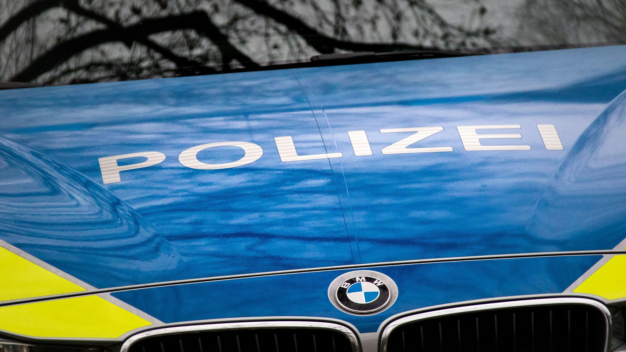 Der Schriftzug „Polizei“ ist auf einem Streifenwagen der Polizei des Landes Nordrhein-Westfalen (NRW) in Köln mit dem BMW-Logo auf der Motorhaube zu sehen.