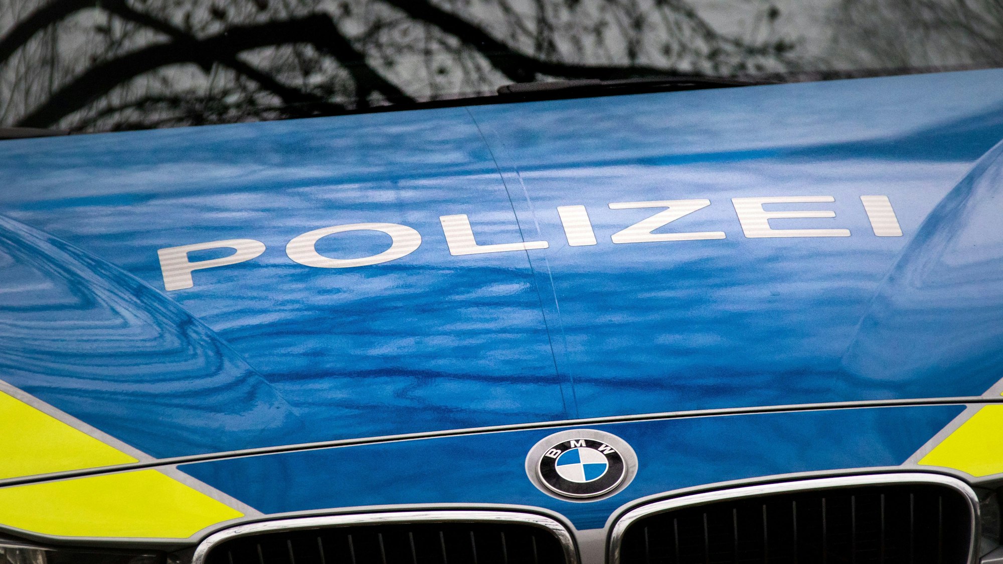 Der Schriftzug „Polizei“ ist auf einem Streifenwagen vom Typ BMW 3er touring der Polizei des Landes Nordrhein-Westfalen (NRW) am Montag in Köln, mit dem BMW-Logo, auf der Motorhaube zu sehen. (Symbolbild)