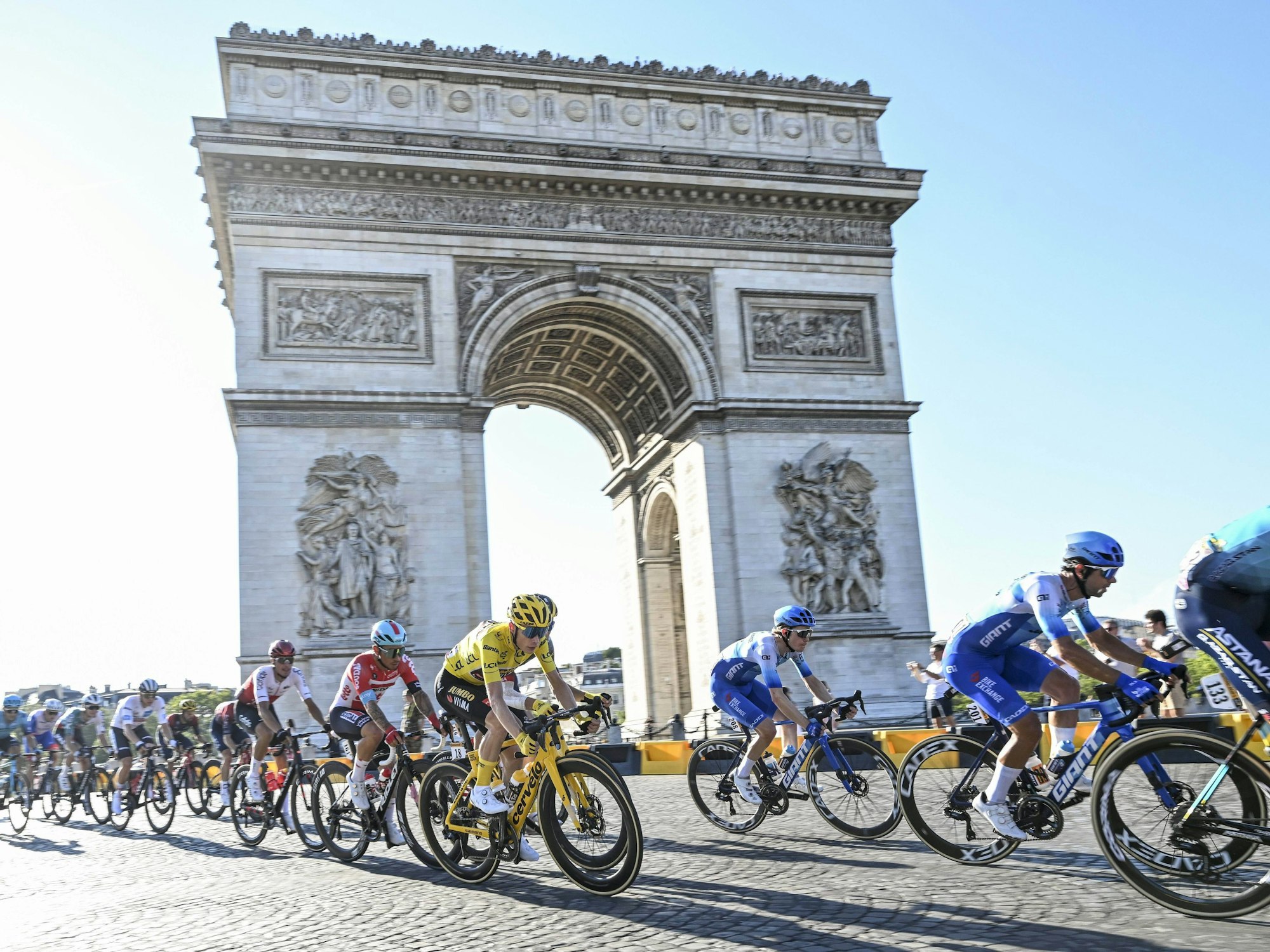 Radfahr-Profis fahren während der Tour de France am Arc de Triomphe in Paris vorbei.