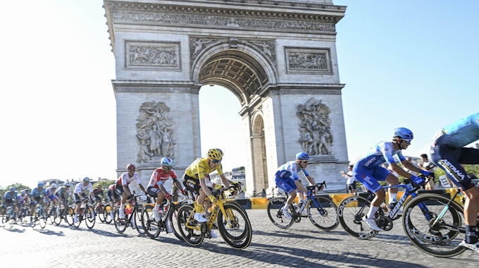 Radfahr-Profis fahren während der Tour de France am Arc de Triomphe in Paris vorbei.