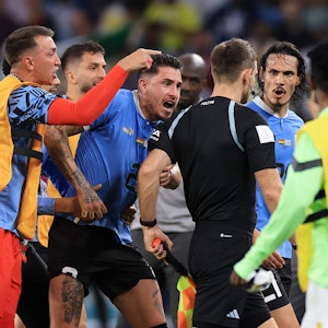 Nationalspieler Uruguays umzingeln den deutschen Schiedsrichter Daniel Siebert nach dem WM-Gruppenspiel gegen Ghana (2:0).