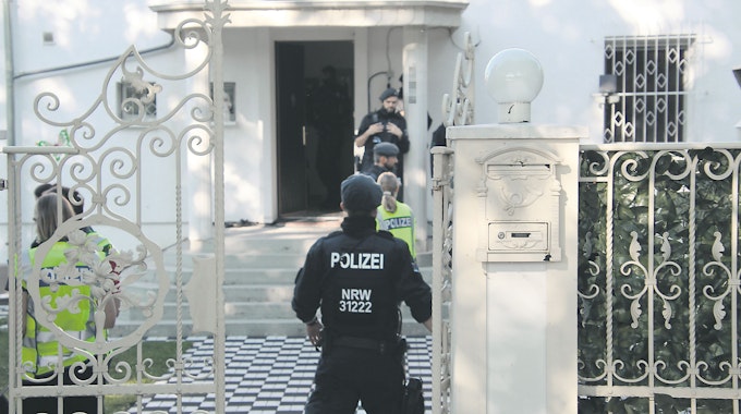 Polizisten bei einer Razzia vor einer Villa im Kölner Stadtteil Ostheim