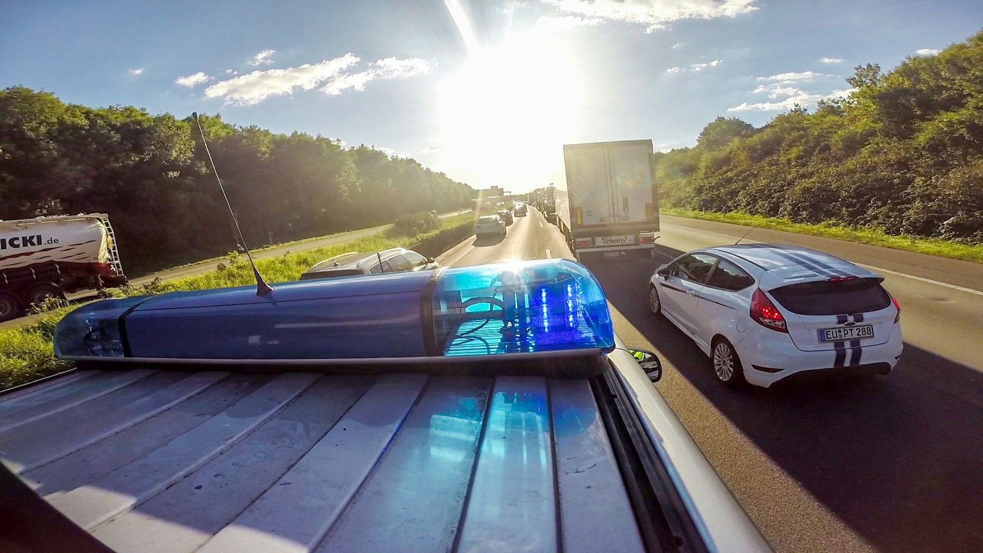 Ein Streifenwagen (VW Multivan) der Autobahnpolizei Koeln faehrt am Montag (28.09.2015) mit Blaulicht und Martinshorn auf der Autobahn A4 in FR Aachen kurz vor der AS Koeln-Poll durch eine Rettungsgasse in einem Verkehrsstau.