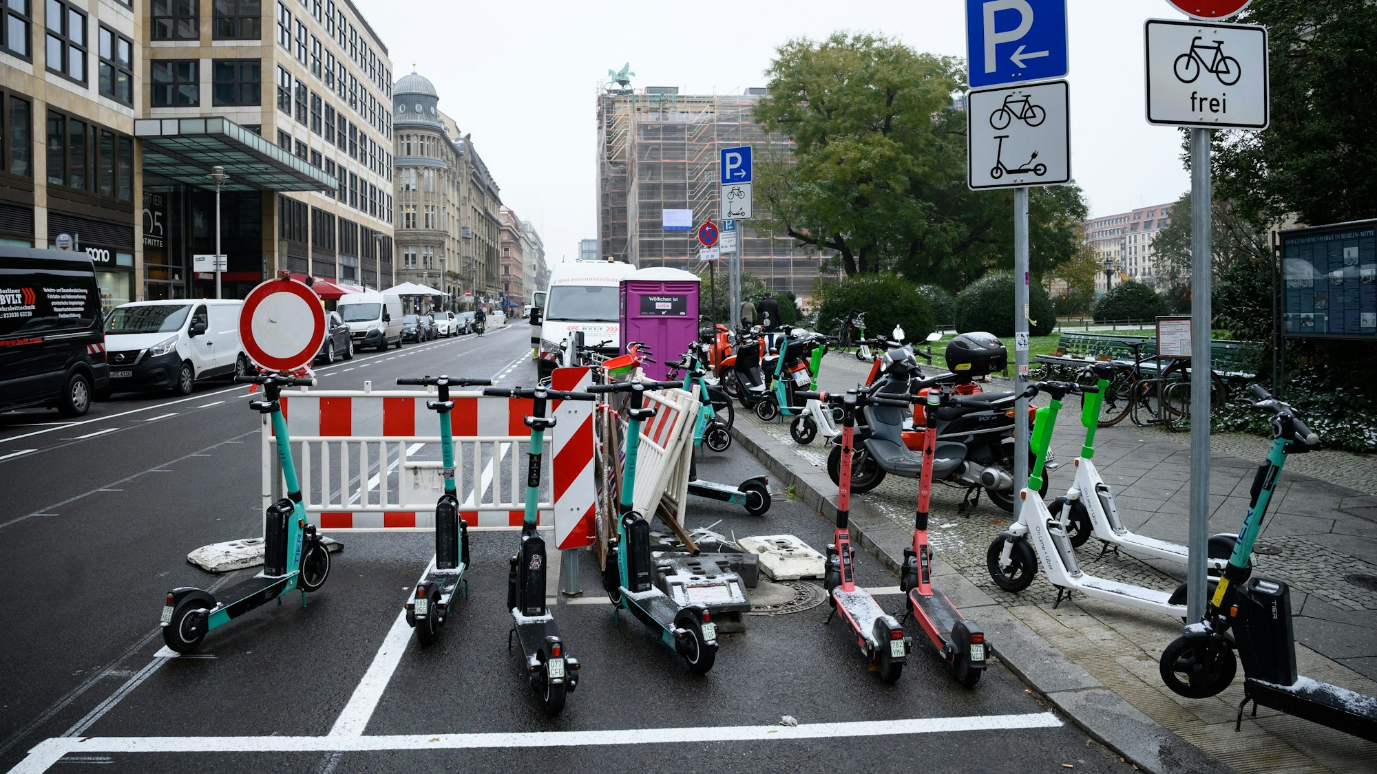 E-Scooter und Roller stehen auf einer Straße in Berlin.
