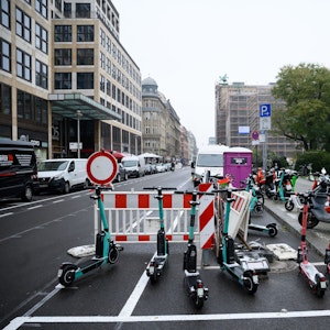 E-Scooter und Roller stehen auf einer Straße in Berlin.