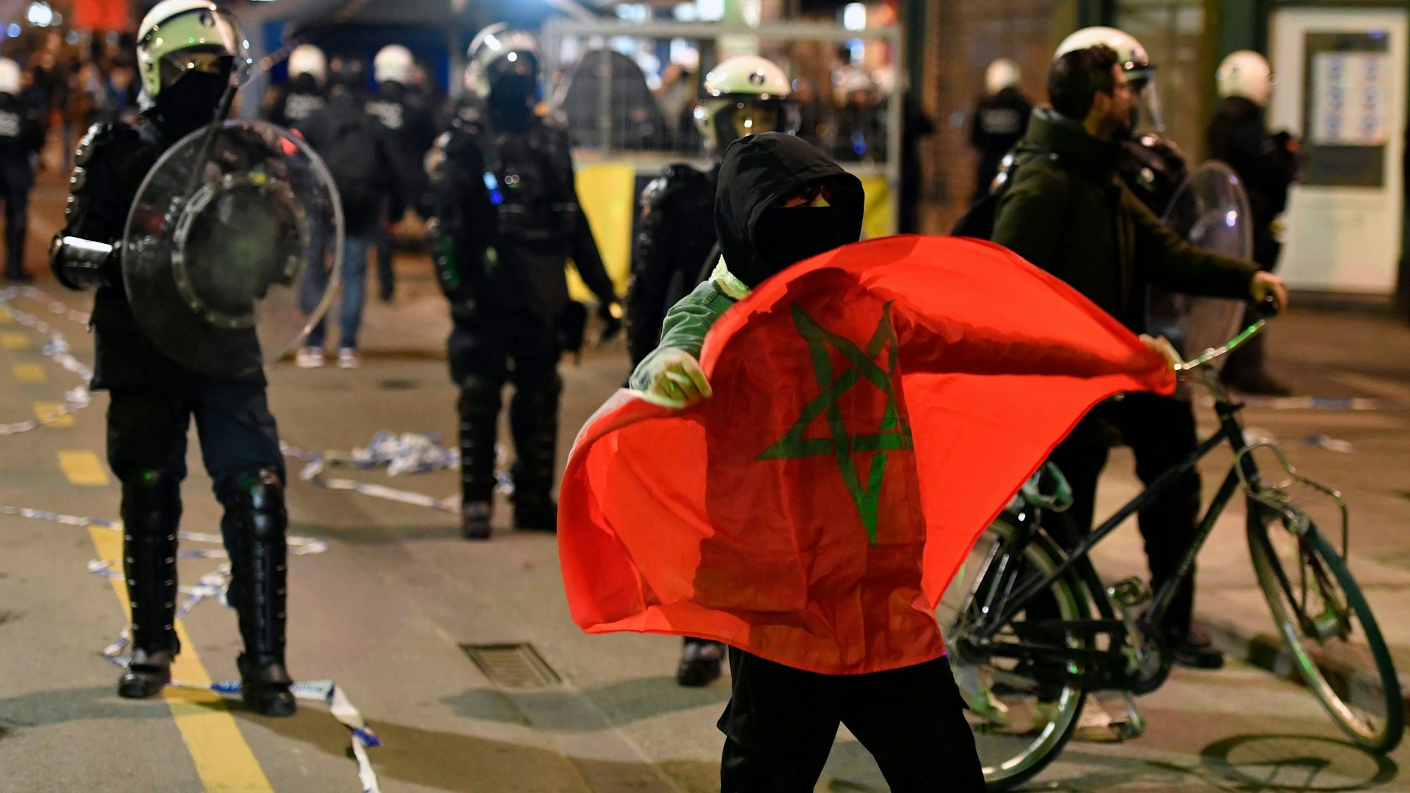 Bereitschaftspolizisten stehen marokkanischen Fans gegenüber, die ihren Einzug in das Achtelfinale derWM feiern.