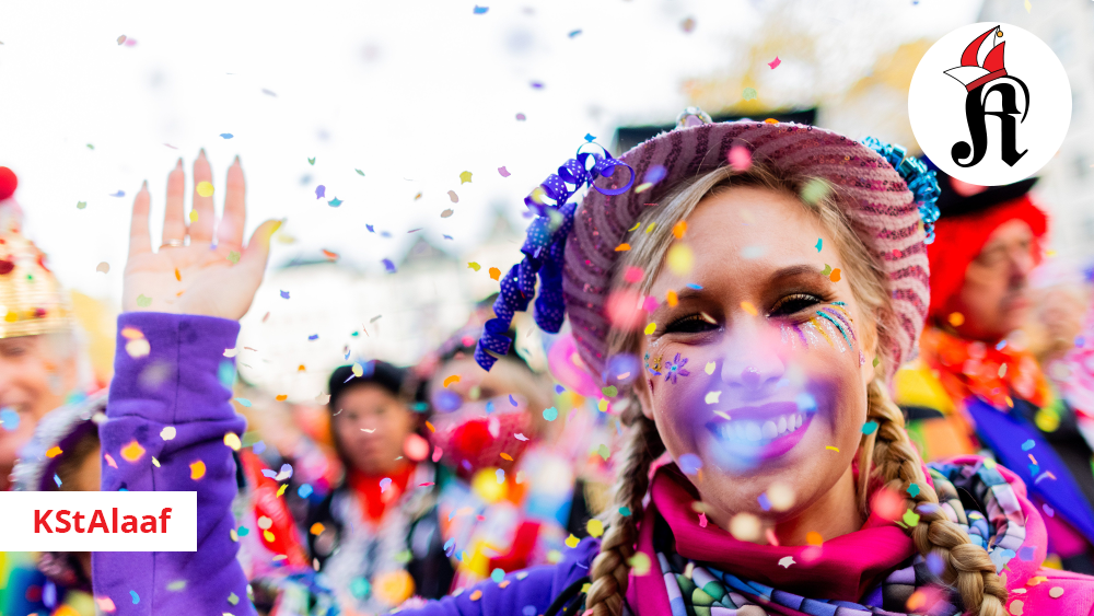 Eine verkleidete Karnevalistin in einer kostümierten Menschenmenge winkt in die Kamera, im Vordergrund rieselt Konfetti. Rechts oben ein Bild mit dem KStA-Logo und einer Narrenkappe.