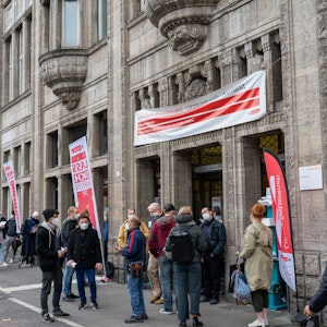 Menschen stehen Schlange vor dem Eingang des Gesundheitsamts in Köln. Hier wollen sie gegen Corona geimpft werden.
