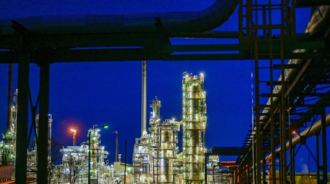 Brandenburg, Schwedt: Die Anlagen der Erdölraffinerie auf dem Industriegelände der PCK-Raffinerie GmbH sind abends beleuchtet. In der Erdölraffinerie kommt Rohöl aus Russland über die Pipeline «Freundschaft» an.