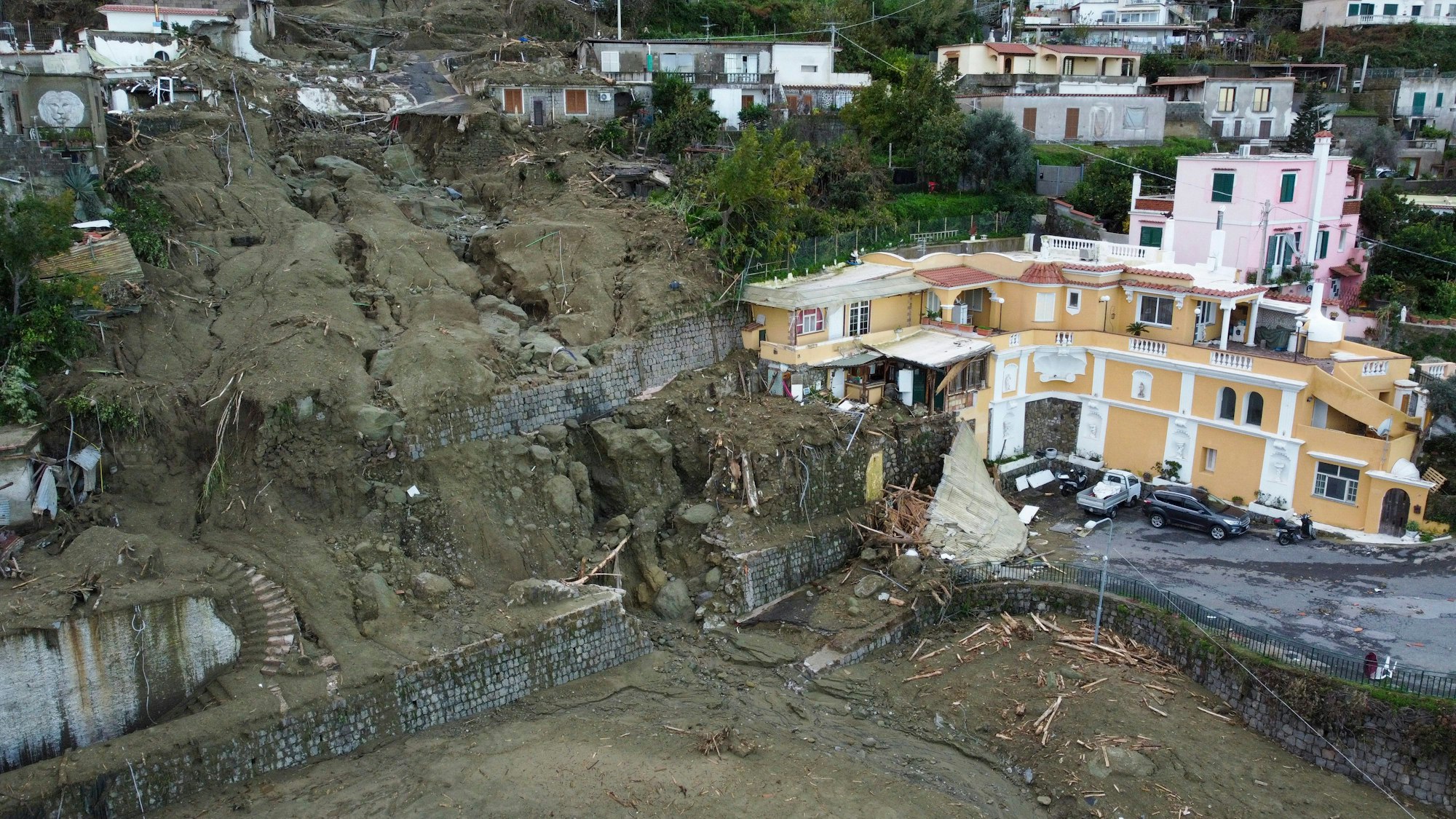 Eine Luftaufnahme zeigt Häuser, die durch das Unwetter und die einhergehenden Erdrutsche beschädigt wurden.