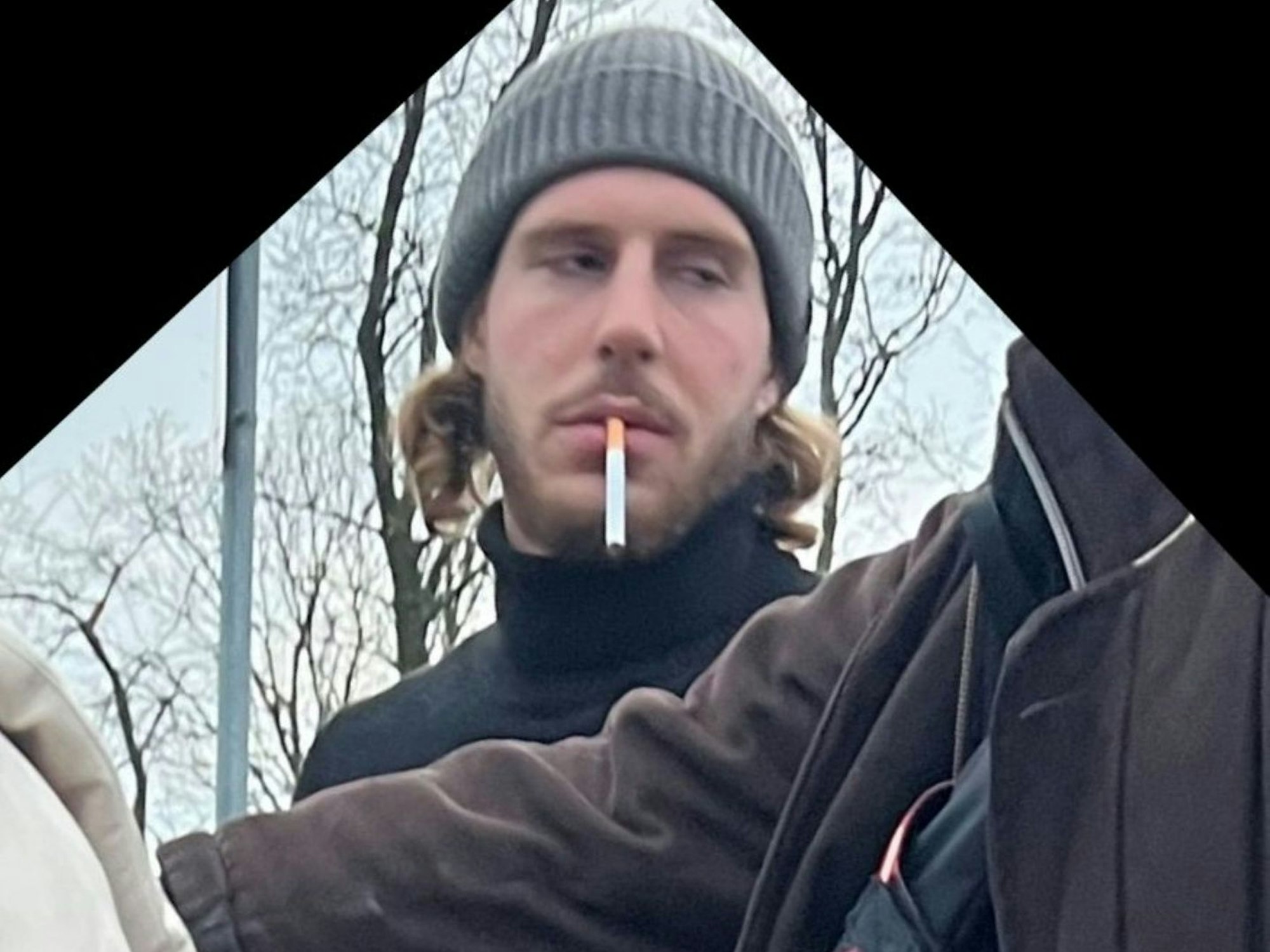Ein Mann, den die Kölner Polizei sucht, hat eine Zigarette im Mund.