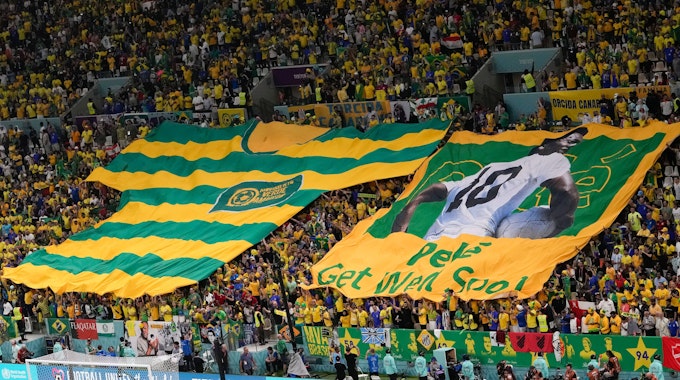 Fans aus Brasilien zeigen ein übergroßes Trikot vom ehemaligen Spieler Pele auf der Tribüne.