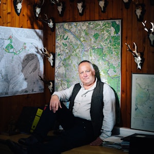 Michael Hundt sitzt in seinem Forsthaus vor einer Landkarte.