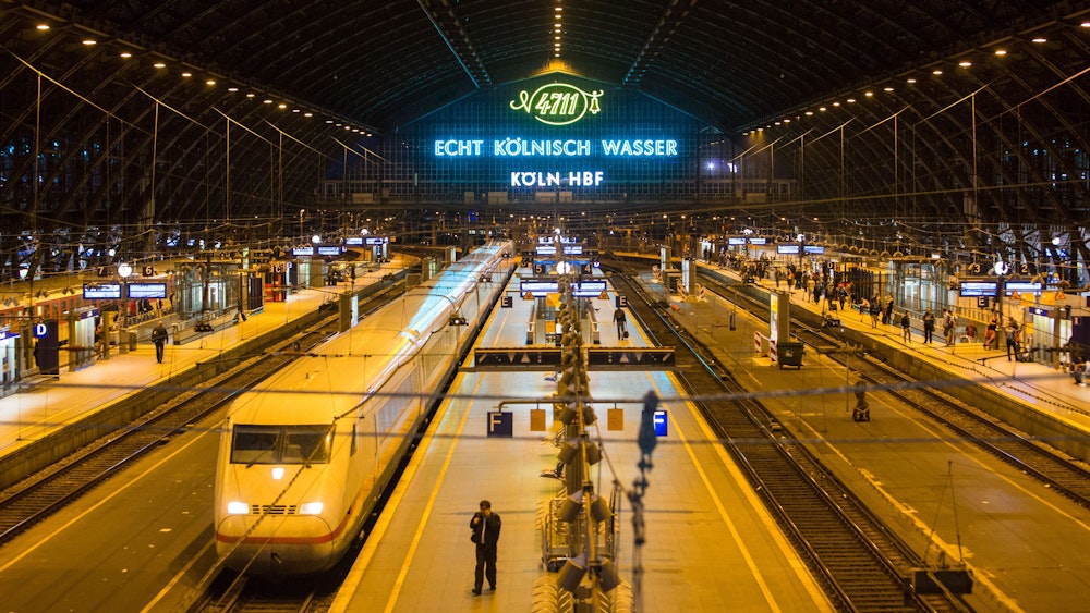Blick auf die Gleise und Bahnsteige im Kölner Hauptbahnhof mit nächtlicher Beleuchtung