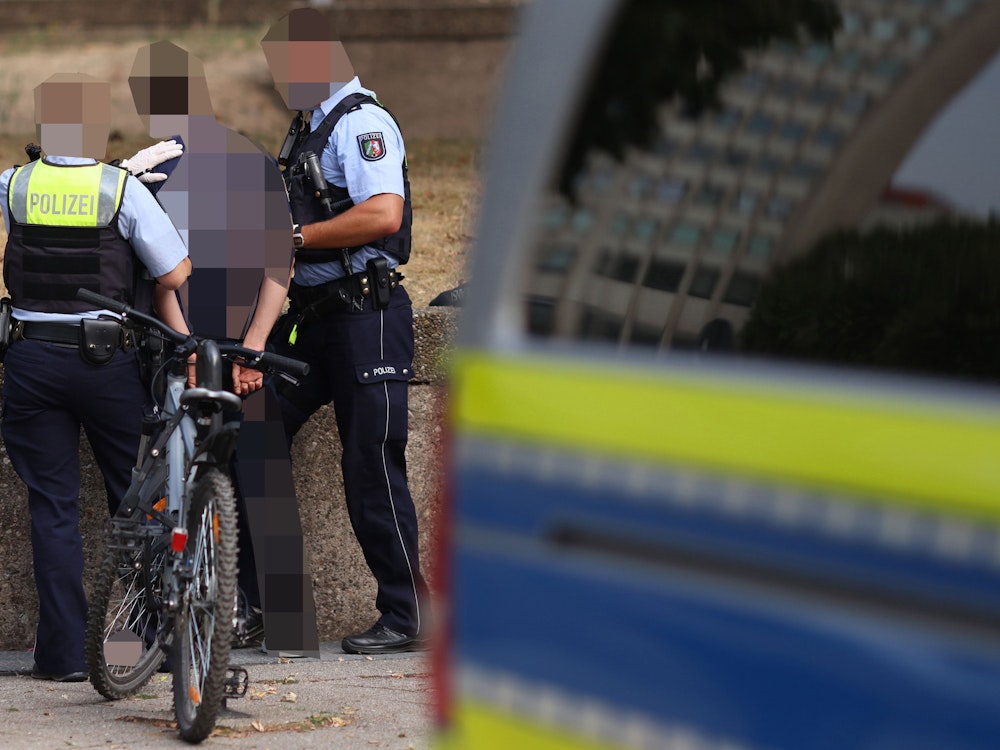 Polizeikräfte nehmen einen Mann fest während einer Razzia der Polizei gegen Drogendealer am Ebertplatz in Köln.