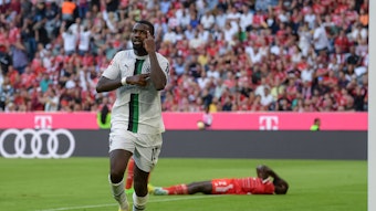 Marcus Thuram erzielt ein Tor für Borussia Mönchengladbach gegen den FC Bayern München am 27. August 2022 und jubelt, während Bayern-Verteidiger Dayot Upamecano auf dem Boden liegt.