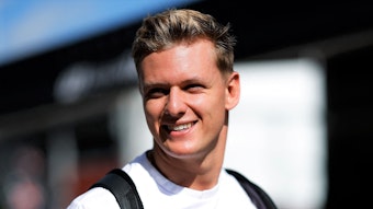 Mick Schumacher geht am Rande des USA-Rennens der Formel 1 in Austin lächelnd durch das Fahrerlager