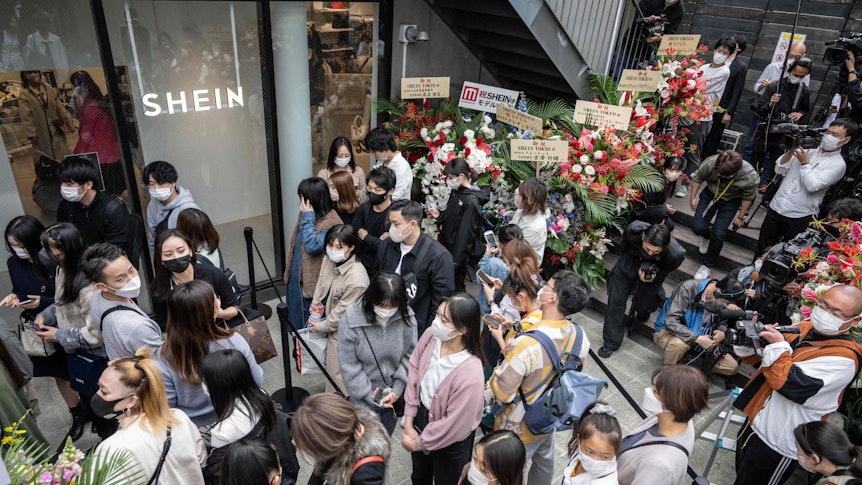 Menschen stehen vor dem ersten Showroom des chinesischen Online-Fast-Fashion-Giganten Shein am Tag der Eröffnung in Tokio am 13. November 2022 Schlange.