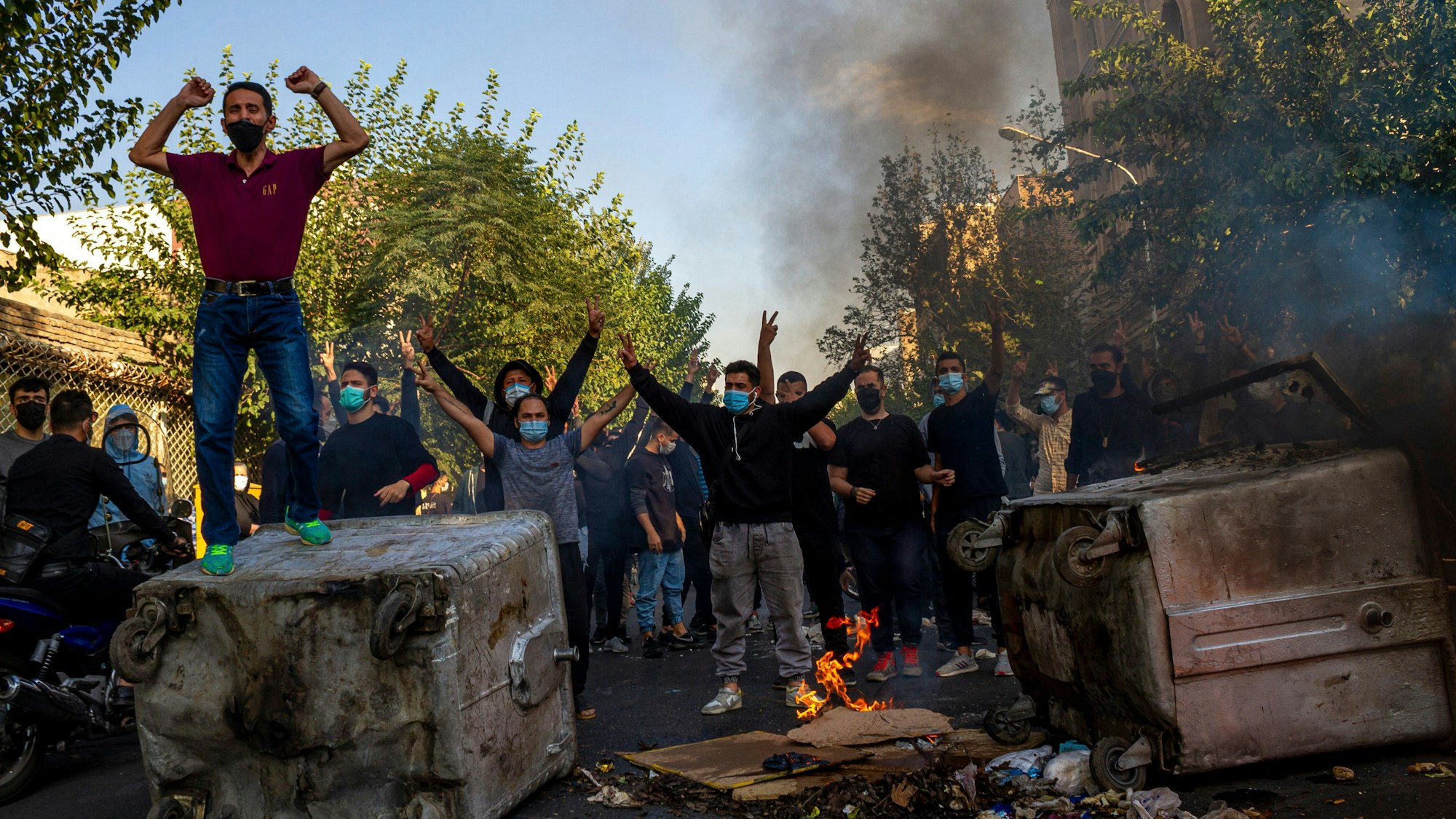 Brennende Gegenstände und Iraner, die nach dem Tod der 22-jährigen Mahsa Amini in Haft der Sittenpolizei gegen das Regime protestieren (Archivbild)