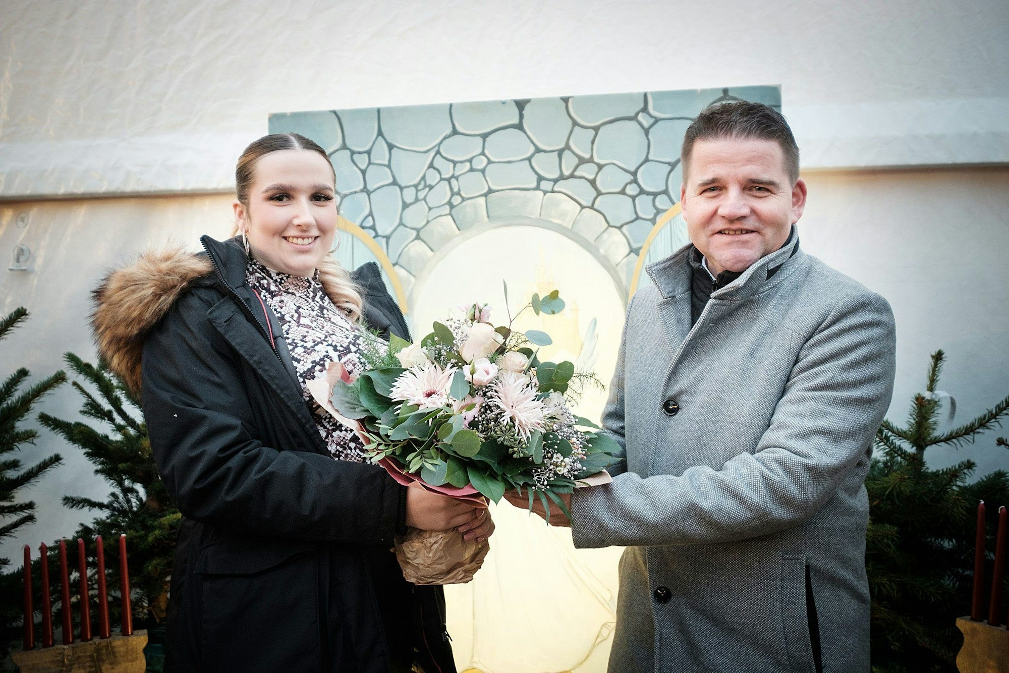BürgermeisterHolger Jung überreicht Blumen an die Meckenheimer Blütenkönigin Celina Kotz, die auch 2023 ihren Heimatort präsentiert