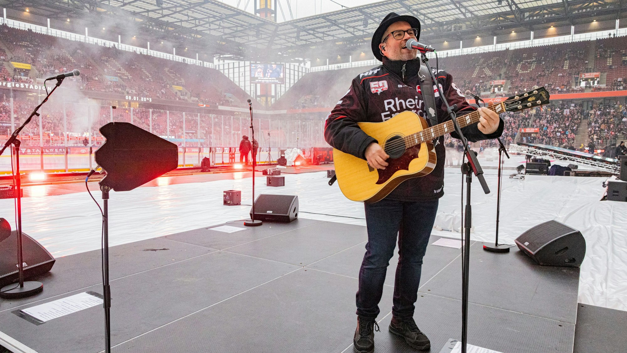 Björn Heuser spielt Gitarre auf der Eisfläche im Stadion in Müngersdorf.