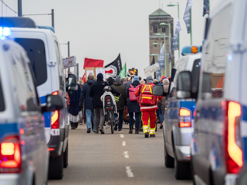 Foto aus der Ferne: Menschen ziehen in einer Demo durch Köln und demonstrieren gegen Rechts.