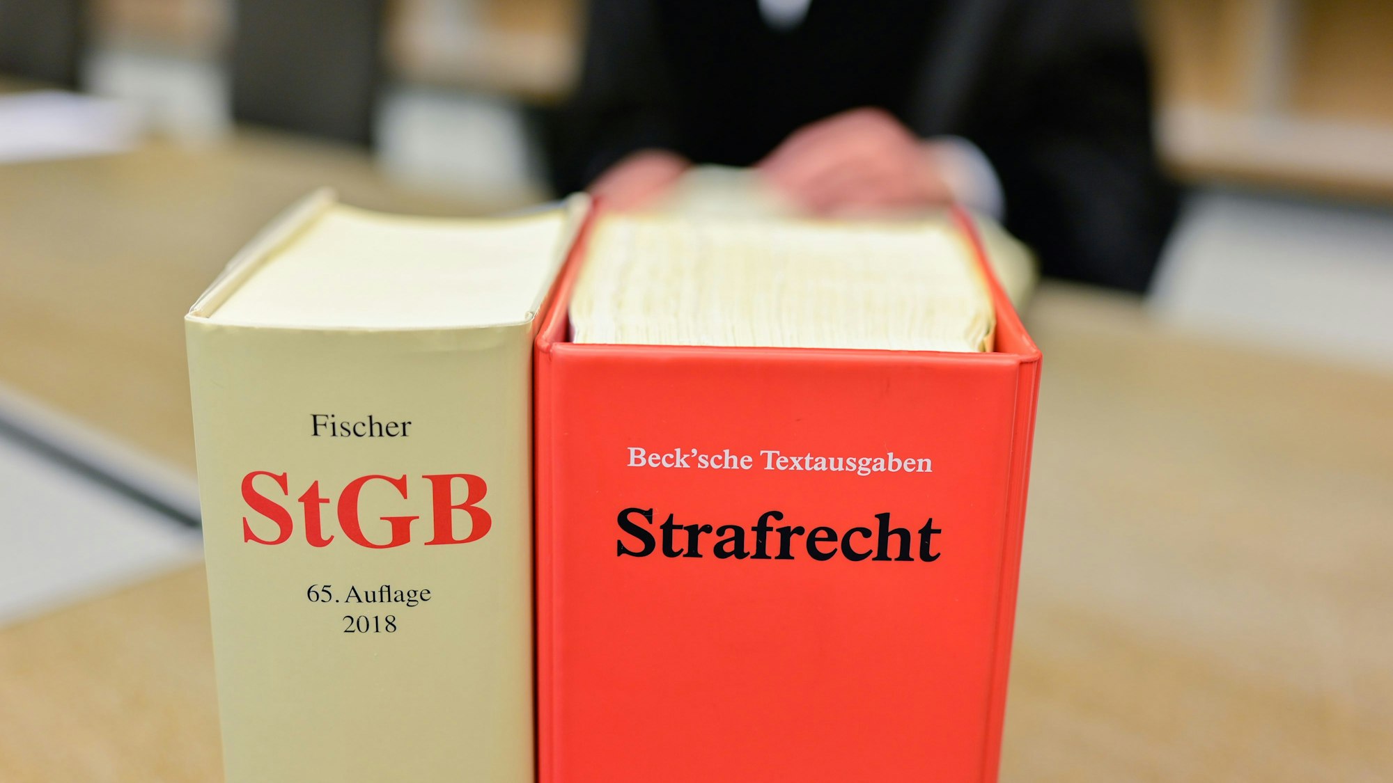 Zwei Bücher mit der Aufschrift „StGB“ und „Strafrecht“.
