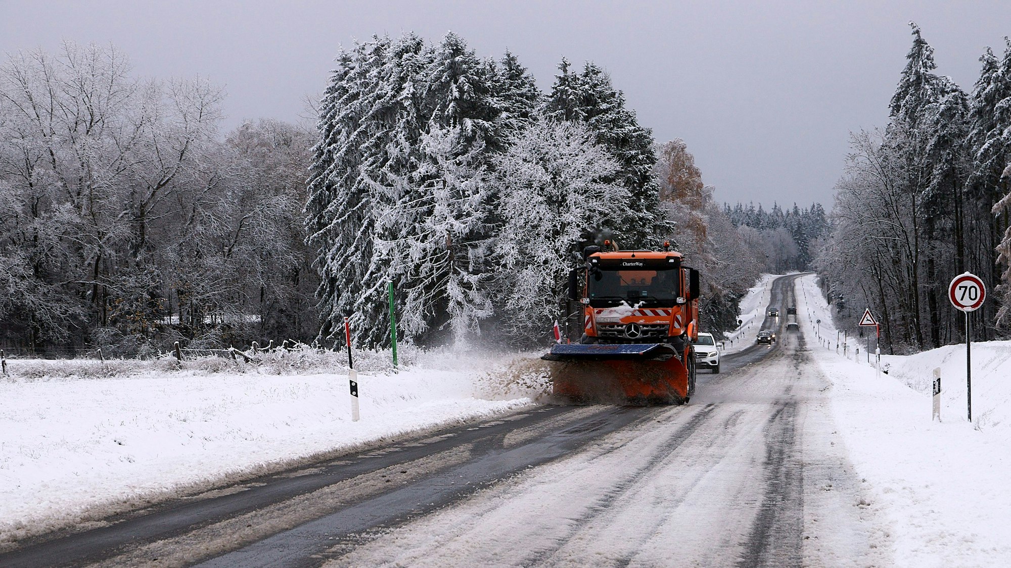 Ein Räumfahrzeug befreit im Berufsverkehr B258 bei Krekel von Schnee und Eis, rechts und links tragen die Fichten schon ein weißes Kleid.