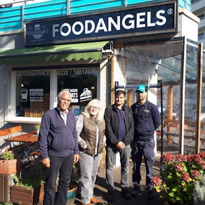 Najib Ramz, Susanna Zeltinger, der betroffene Fazal Rabi Rahimzai und 'Foodangels'-Betreiber Mazlom Sediqi stehen vor dem Restaurant „Foodangels“ in Köln.