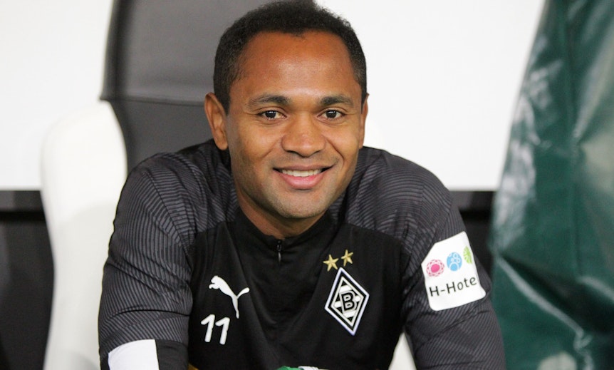 Ex-Gladbach-Star Raffael. Auf diesem Bild ist der gebürtige Brasilianer mit deutschem Pass am 19. September 2019 im Borussia-Park zu sehen. Raffael sitzt auf der Bank und lächelt.