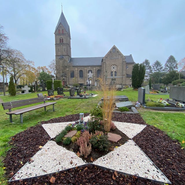 Im Hintergrund steht die St. Servatius Kirche. Vor der Kirche befindet sich ein Friedhof. Das Grabfeld für tote Kinder ist in Form eines Sterns angelegt.&nbsp;