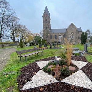 Im Hintergrund steht die St. Servatius Kirche. Vor der Kirche befindet sich ein Friedhof. Das Grabfeld für tote Kinder ist in Form eines Sterns angelegt.