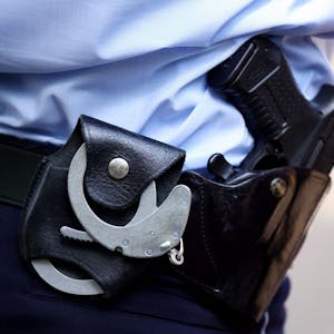 Ein Polizist mit Handschellen und Pistole am Gürtel. (Symbolbild)